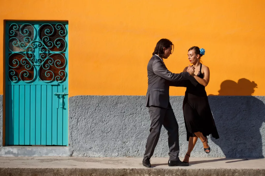 Par som danser utenfor gul vegg