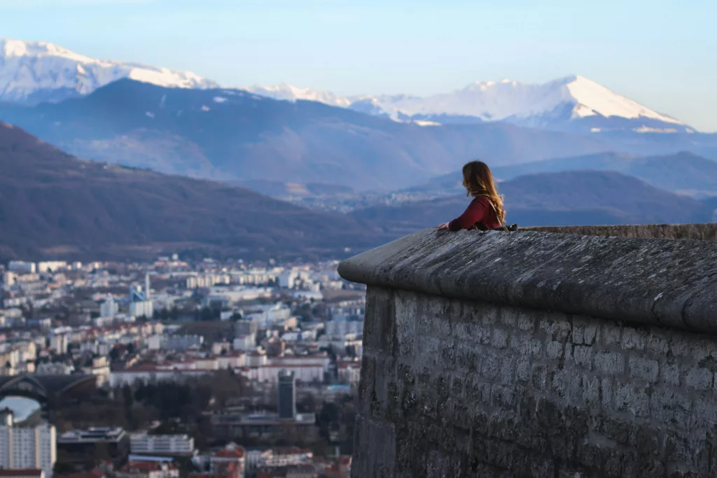 Kvinne ser utover Grenoble med fjell i bakgrunnen