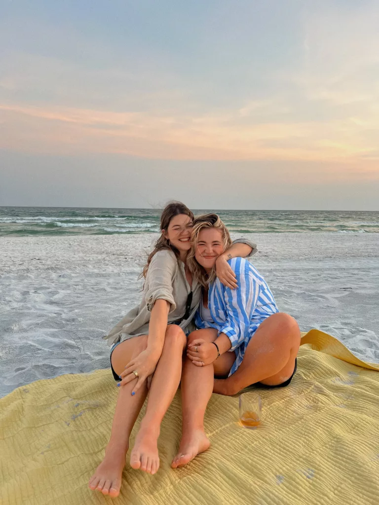 To jenter smiler på en strand