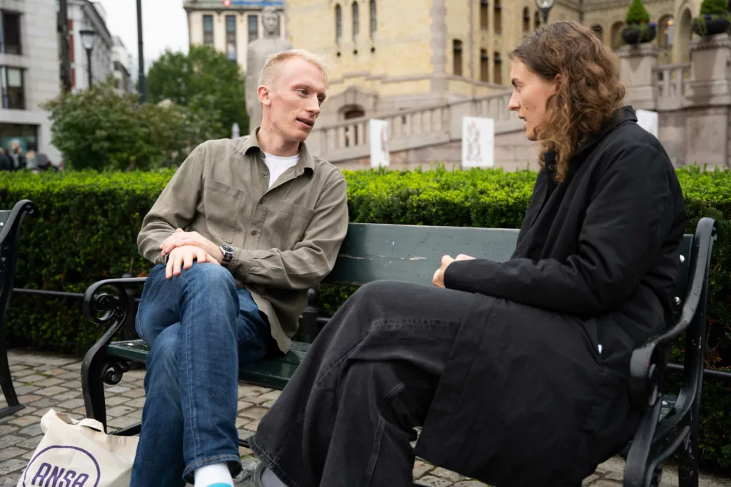 Øyvind Bryhn Pettersen og Aurora Ørstavik på en benk foran Stortinget.